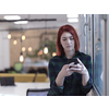 redhead business woman as influencer in creative modern coworking startup open space office using smart phone