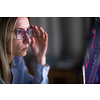 Stylish mid-aged woman looking concerned while remote working from home, staring at the computer screeen for long hours, exhausting her eyes with blue light