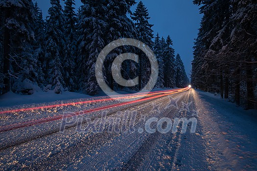 Cars on a snowy winter road amid forests - using its four wheel drive capacities to get through the snow - motion blurred image Cars on a snowy winter road amid forests - using its four wheel drive capacities to get through the snow - motion blurred image
