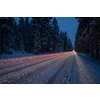 Cars on a snowy winter road amid forests - using its four wheel drive capacities to get through the snow - motion blurred image