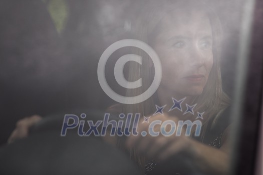 Pretty midle aged woman at the steering wheel of her car commuting to work Pretty midle aged woman at the steering wheel of her car commuting to work