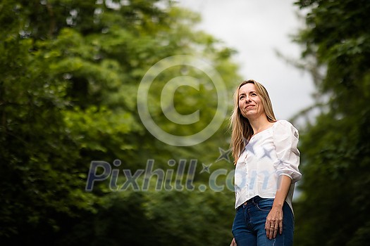 Portrait of a relaxed middle aged woman outdoors, looking happy, enjoying the life Portrait of a relaxed middle aged woman outdoors, looking happy, enjoying the life