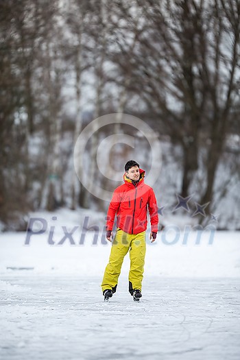 Young man ice skating outdoors on a pond on a freezing winter day Young man ice skating outdoors on a pond on a freezing winter day