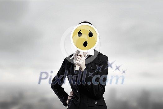 Unrecognizable businesswoman hiding her face behind sad mask Unrecognizable businesswoman hiding her face behind sad mask
