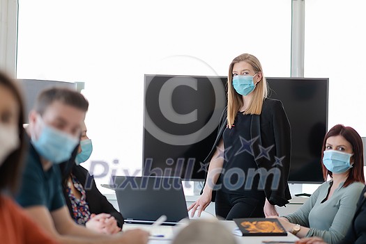 real businesspeople on business meeting in bright office on coronavirus new normal time wearing protective medical face mask and keep distance