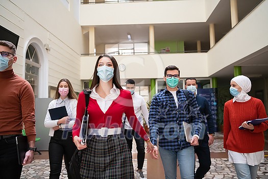 multiethnic students group walking on university coridor wearing protective face mask in new normal coronavirus pandemic lifestyle in education multiethnic students group walking on university coridor wearing protective face mask in new normal coronavirus pandemic lifestyle in education