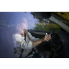 Pretty midle aged woman at the steering wheel of her car, going fast
