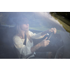 Pretty midle aged woman at the steering wheel of her car, going fast