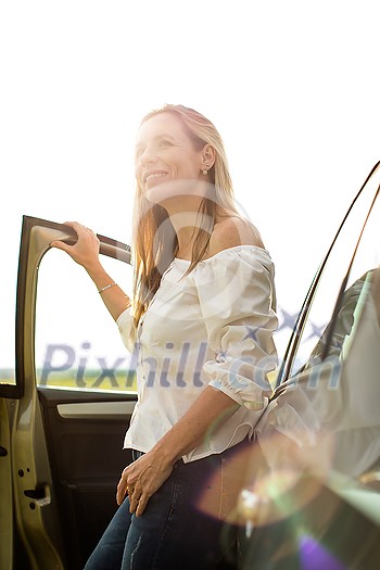 Pretty middle aged woman at the steering wheel of her car Pretty middle aged woman at the steering wheel of her car