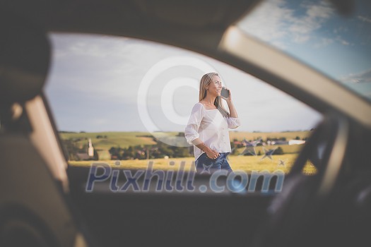 Pretty midle aged woman at the steering wheel of her car, having a break on a long trip, making a phone call Pretty midle aged woman at the steering wheel of her car, having a break on a long trip, making a phone call