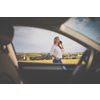 Pretty midle aged woman at the steering wheel of her car, having a break on a long trip, making a phone call