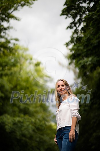 Portrait of a relaxed middle aged woman outdoors, looking happy, enjoying the life Portrait of a relaxed middle aged woman outdoors, looking happy, enjoying the life