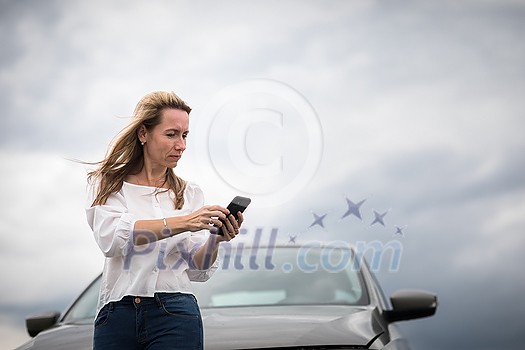 Pretty middle aged woman having car troubles - broken down car on the side of the road, calling the insurance company for assistance Pretty middle aged woman having car troubles - broken down car on the side of the road, calling the insurance company for assistance