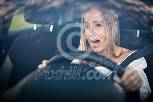 Pretty middle aged woman at the steering wheel of her car Pretty middle aged woman at the steering wheel of her car