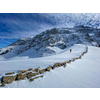 Winter sports - young man walking with snowshoes uphill in high mountains covered with lots of snow