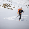 Winter sports - young man walking with snowshoes in high mountains covered with lots of snow (selective focus on the mountain in the background)