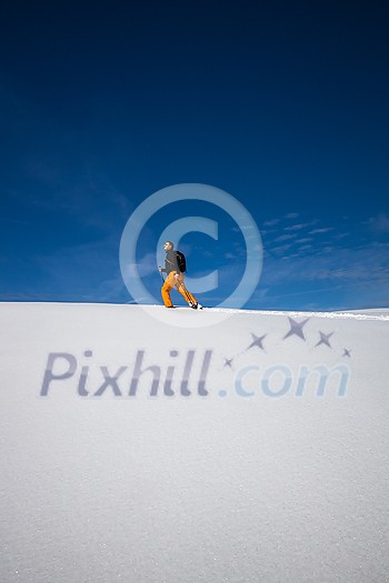 Winter sports - young man running with snowshoes downhill in high mountains covered with lots of snow Winter sports - young man running with snowshoes downhill in high mountains covered with lots of snow