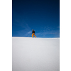 Winter sports - young man running with snowshoes downhill in high mountains covered with lots of snow