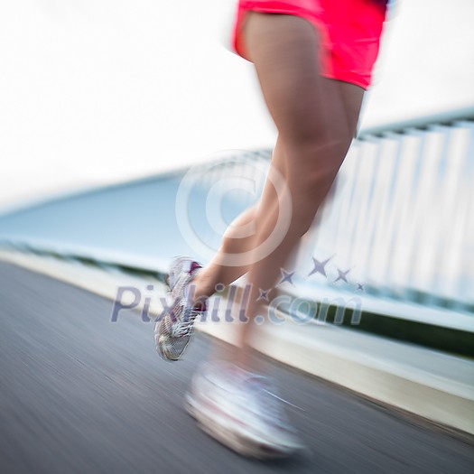 Young woman jogging outdoors (motion blurred image) Young woman jogging outdoors (motion blurred image)