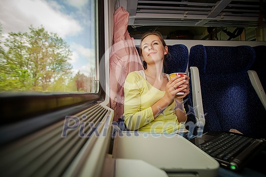 Young woman traveling by train (landscape moving fast behind the window (<--- motin blurred image) Young woman traveling by train (landscape moving fast behind the window (<--- motin blurred image)