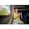 Young woman traveling by train (landscape moving fast behind the window (<--- motin blurred image)