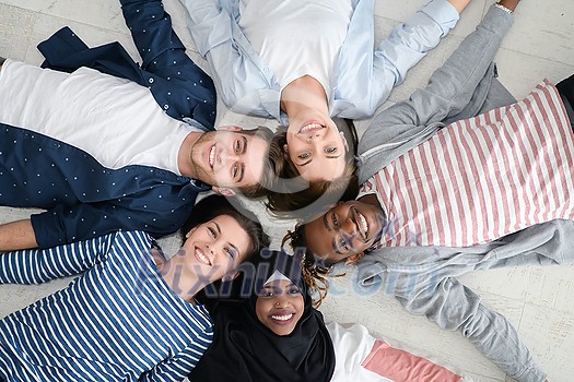 a top view of a diverse group of people lying on the floor and symbolizing togetherness
