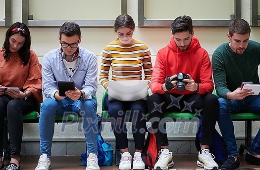 a group of students sit in the school hallway and use notebooks, tablets and cameras to create projects for the school a group of students sit in the school hallway and use notebooks, tablets and cameras to create projects for the school
