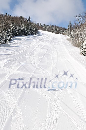 tracks on ski slopes in snow at beautiful sunny winter day with blue sky tracks on ski slopes in snow at beautiful sunny winter day with blue sky