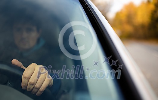 Young man at the steering wheel of his car commuting to work Young man at the steering wheel of his car commuting to work