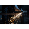 Man working on iron with grinder. Man at work. Sparkles and fire from grinder cutting. Grinder. Worker.