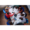 Top view of university students sitting at a table studying and working on laptop