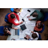 Top view of university students sitting at a table studying and working on laptop