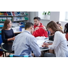 students in a modern environment work together to more easily complete a school project