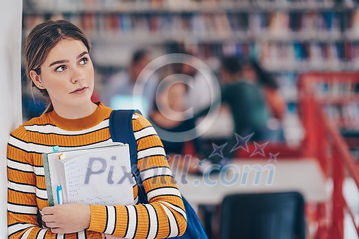 a portrait of a girl holding a notebook in her hand while standing in front of the library a portrait of a girl holding a notebook in her hand while standing in front of the library
