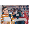 a portrait of a girl holding a notebook in her hand while standing in front of the library
