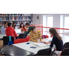 a group of students sit in a library and create a project for a school with the help of modern technology