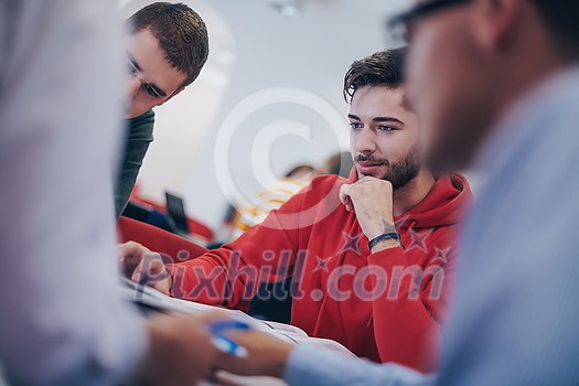 a group of students sit in a library and create a project for a school with the help of modern technology a group of students sit in a library and create a project for a school with the help of modern technology