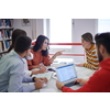 a group of students sit in a library and create a project for a school with the help of modern technology