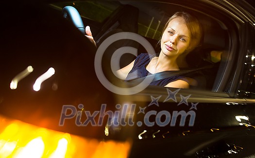 Driving a car at night - pretty, young woman driving her modern car at night, in a city (shallow DOF; color toned image) Driving a car at night - pretty, young woman driving her modern car at night, in a city (shallow DOF; color toned image)