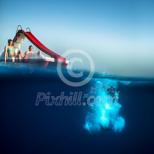 Group of friends on a boat . Guy diving underwater Group of friends on a boat . Guy diving underwater