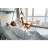 Patient at a hospital, looking from a window in his room, doing much better after the surgery