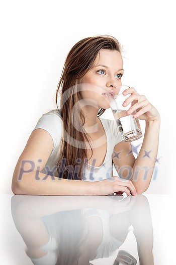 Pretty, young woman in her modern, clean and bright kitchen, pouring herself and drinking a glass of cold tap water(color toned imagey; shallow DOF) Pretty, young woman in her modern, clean and bright kitchen, pouring herself and drinking a glass of cold tap water(color toned imagey; shallow DOF)