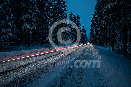 Cars on a snowy winter road amid forests - using its four wheel drive capacities to get through the snow - motion blurred image Cars on a snowy winter road amid forests - using its four wheel drive capacities to get through the snow - motion blurred image