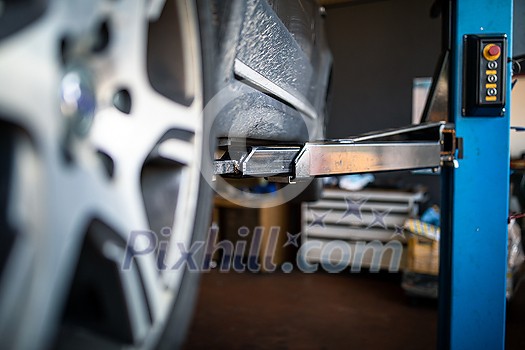 Car in a garage for maintenance, oil/tyre change (shallow DOF; color toned image) Car in a garage for maintenance, oil/tyre change (shallow DOF; color toned image)