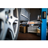 Car in a garage for maintenance, oil/tyre change (shallow DOF; color toned image)