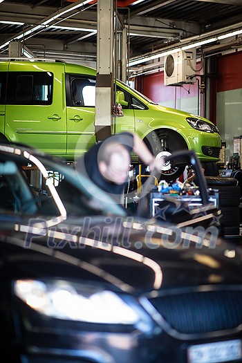 Tyre change - wheel balancing or repair and change car tire at auto service garage or workshop by mechanic Tyre change - wheel balancing or repair and change car tire at auto service garage or workshop by mechanic