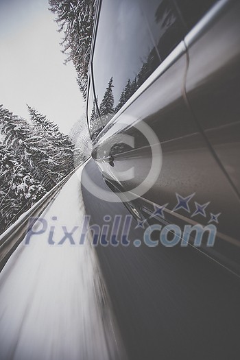 Fast moving car on a winter alpine snowy road Fast moving car on a winter alpine snowy road