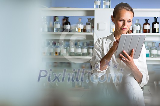 Portrait of a female researcher doing research in a lab, using a tablet computer for data collection and visualization(shallow DOF; color toned image) Portrait of a female researcher doing research in a lab, using a tablet computer for data collection and visualization(shallow DOF; color toned image)
