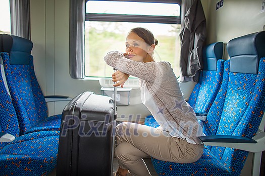 Pretty young woman aboard a train, going for her vacation destination Pretty young woman aboard a train, going for her vacation destination