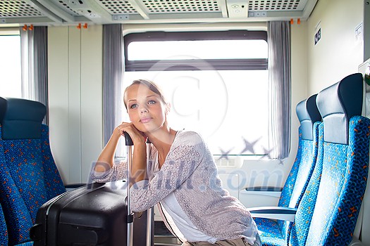 Pretty young woman aboard a train, going for her vacation destination Pretty young woman aboard a train, going for her vacation destination